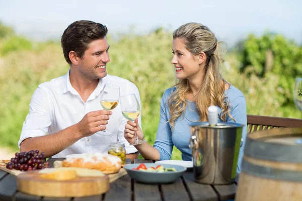 Vrienden roosteren wijnglazen aan tafel — Stockfoto