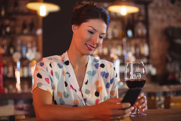 Mujer usando el teléfono mientras toma vino —  Fotos de Stock