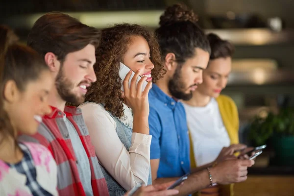 Young friends using mobile phones — Stock Photo, Image