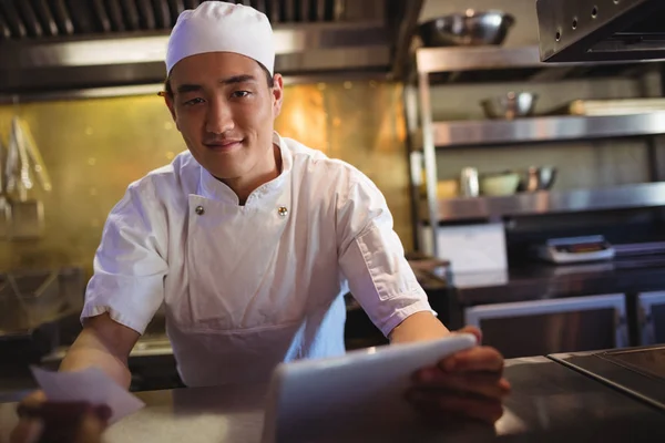 Chef-kok holding digitale tablet en een bestellijst — Stockfoto