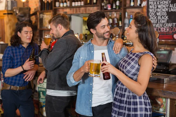 Vrienden houden bierglas en fles door teller — Stockfoto