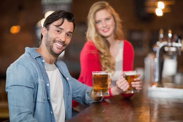 Adam ve barda bira gözlük tutan kadın — Stok fotoğraf