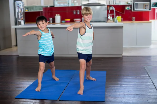 Sorridenti fratelli che fanno esercizio di stretching — Foto Stock