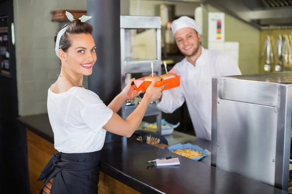 Шеф-кухар дає бургери для офіціантки на кухні — стокове фото