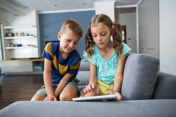 Broers en zussen met behulp van digitale tablet in woonkamer — Stockfoto