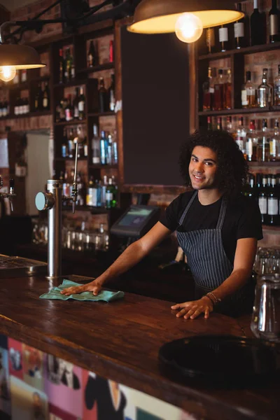 Young waiter cleaning a counter — Stock Photo, Image