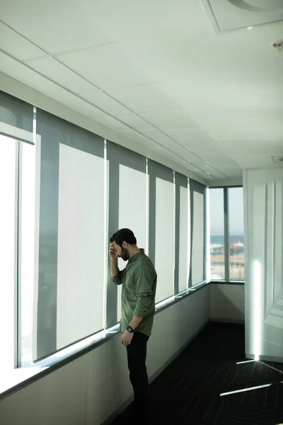 Orolig business executive stående av fönster — Stockfoto