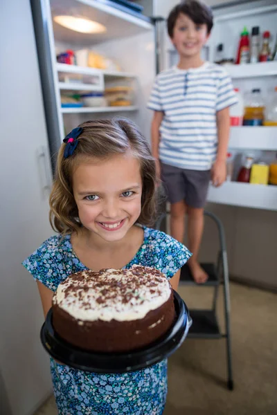 Girl holding cake in kitchen — Stock Photo, Image