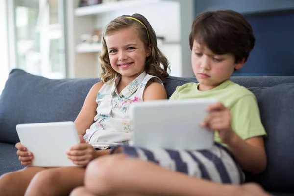 Broers en zussen met behulp van digitale tablet in woonkamer — Stockfoto