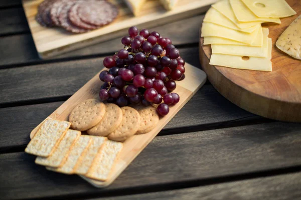 Uvas rojas con galletas y queso en la mesa — Foto de Stock