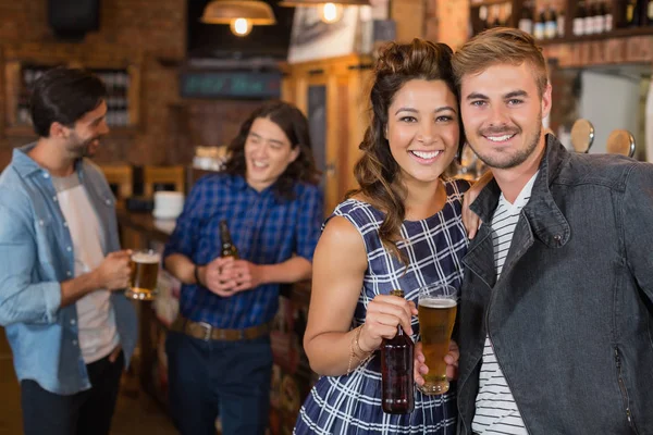 Amici che tengono bicchiere di birra e bottiglia in pub — Foto Stock