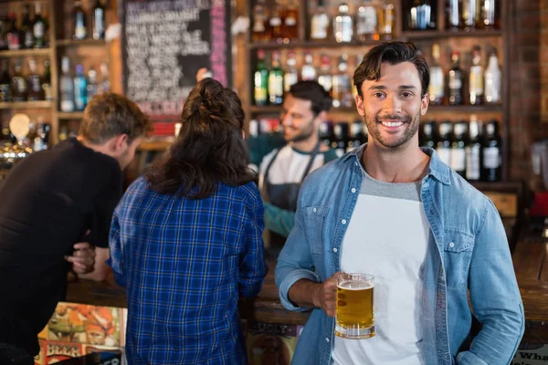 Sorridente homem segurando cerveja caneca i bar — Fotografia de Stock