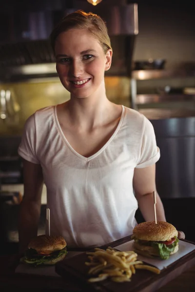 Жінка тримає бургер і картоплю фрі — стокове фото