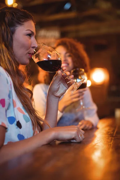 Mujeres jóvenes tomando vino tinto en el pub —  Fotos de Stock