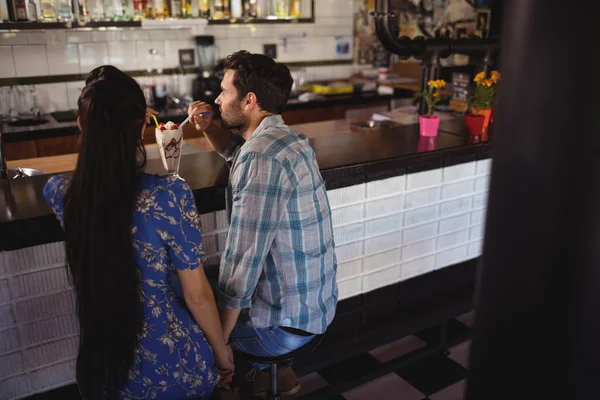 Couple holding hands while having milkshake — Stock Photo, Image