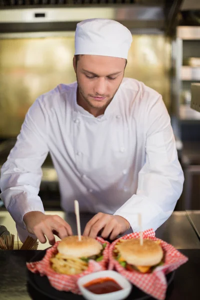 Serious male chef preparing burger — Stock Photo, Image
