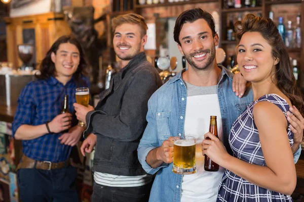 Amigos com garrafas de cerveja e copos no pub — Fotografia de Stock