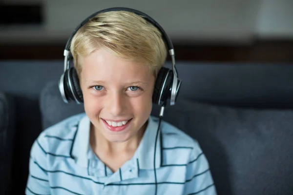 Niño escuchando música en auriculares en la sala de estar —  Fotos de Stock