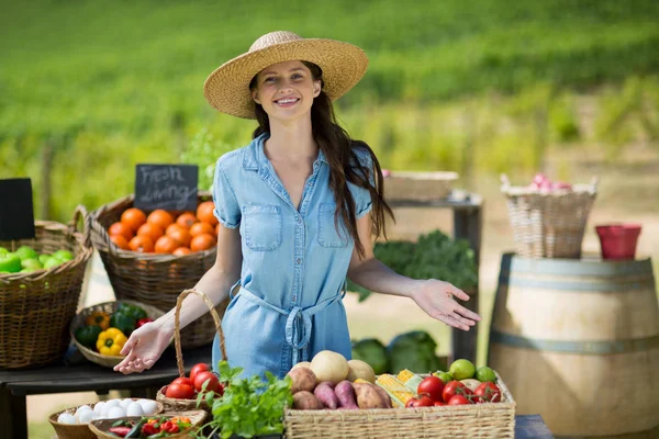 Усміхнена жінка, що продає овочі — стокове фото
