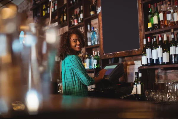 Female bar tender using electronic machine — Stock Photo, Image