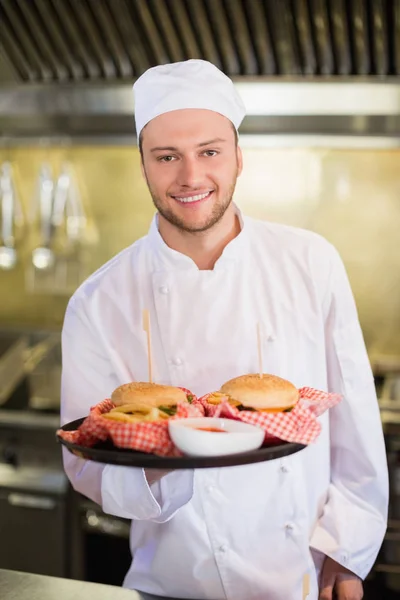 Professional chef holding burgers in plate — Stock Photo, Image