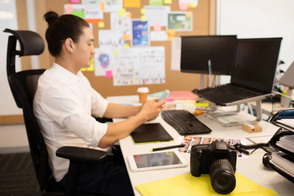 Designer usando telefone na mesa de escritório criativo — Fotografia de Stock