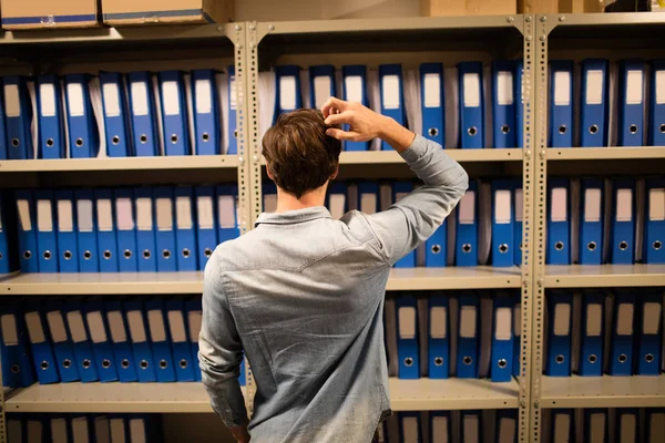 Empresário confuso em busca de arquivos no gabinete — Fotografia de Stock