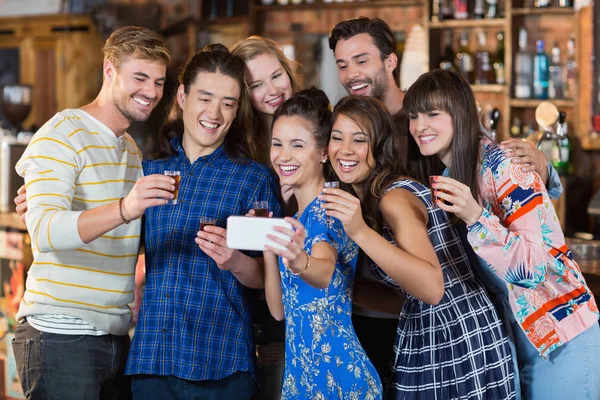 Amigos tomando selfie mientras sostiene gafas cortas — Foto de Stock