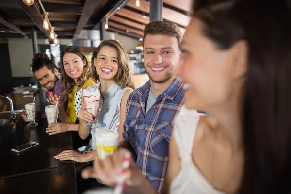 Groep vrienden met dranken in restaurant — Stockfoto