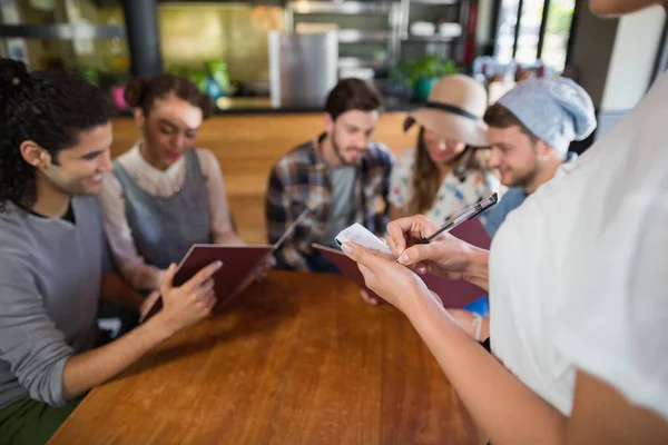 Serveerster nemen van de bestellingen van klanten in restaurant — Stockfoto