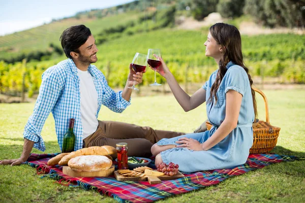 Glückliches Paar beim Anstoßen auf Weingläser — Stockfoto