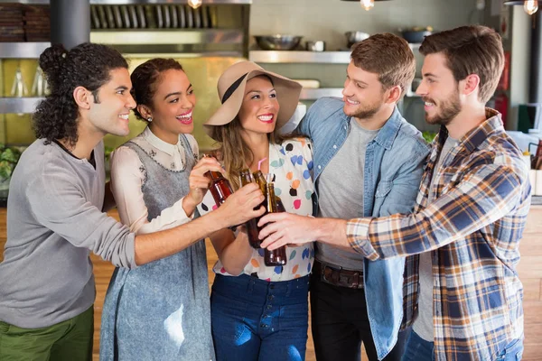 Amigos tostando botellas de cerveza en el restaurante —  Fotos de Stock