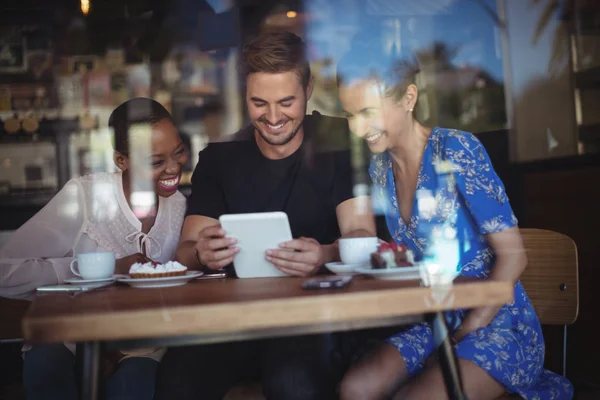 Amis utilisant la tablette tout en prenant le petit déjeuner — Photo