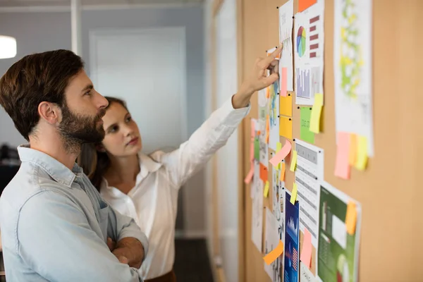 Zakenman met vrouwelijke collega analyseren van grafieken — Stockfoto