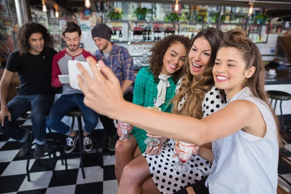 Alegres amigas tomando selfie no restaurante — Fotografia de Stock