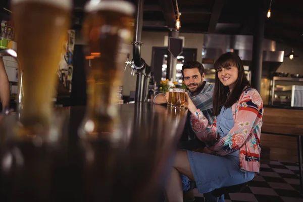 カウンターでビールのガラスを保持しているカップル — ストック写真