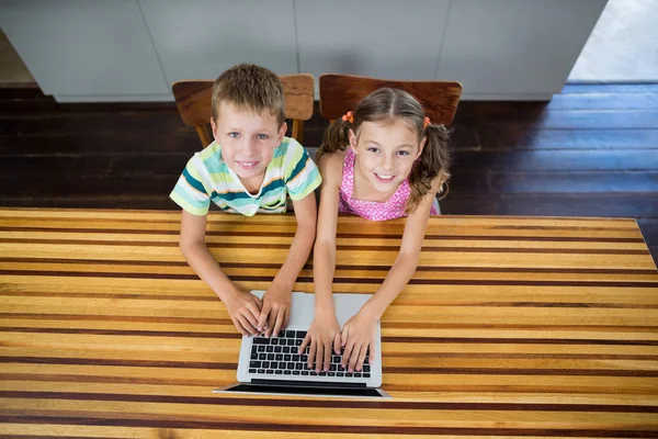 Lächelnde Geschwister mit Laptop in der Küche — Stockfoto
