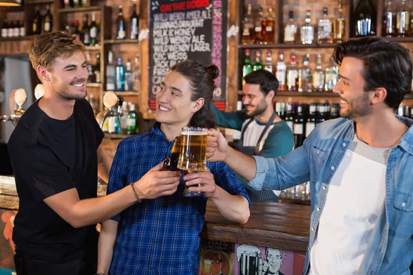 Mužských přátel opékání džbánky na pivo a láhev — Stock fotografie