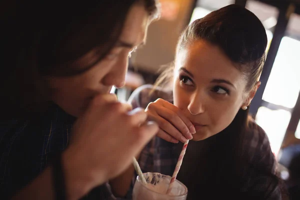 Close-up of couple having milkshake — Stock Photo, Image