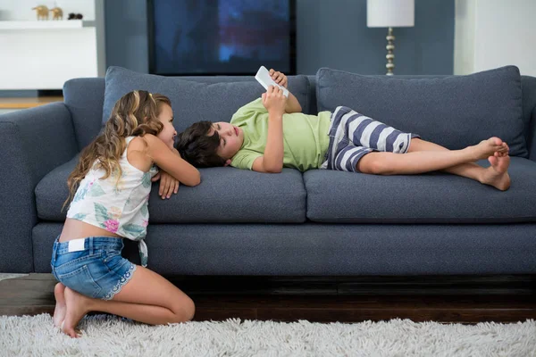 Hermanos usando tableta digital en sala de estar —  Fotos de Stock