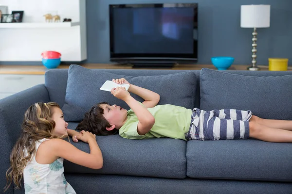 Broers en zussen met behulp van digitale tablet in woonkamer — Stockfoto