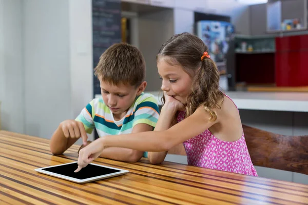 Geschwister nutzen digitales Tablet in Küche — Stockfoto