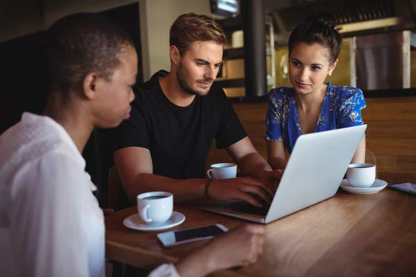 Vrienden met behulp van de laptop terwijl het hebben van koffie — Stockfoto