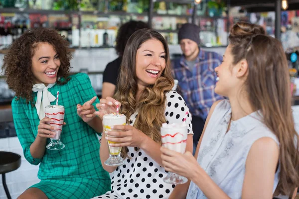 Female friends enjoying while having drink — Stock Photo, Image