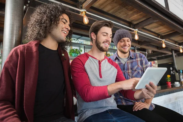 Amigos do sexo masculino usando tablet digital no restaurante — Fotografia de Stock