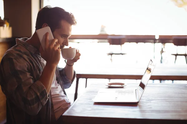 Kahve yaparken telefonla konuşan adam — Stok fotoğraf