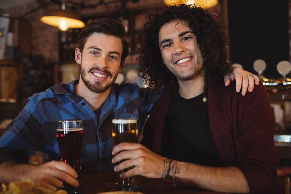 Amigos tomando cerveja no balcão do bar — Fotografia de Stock