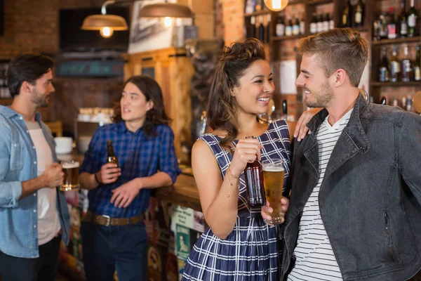 Vrienden houden bierglas en fles in pub — Stockfoto