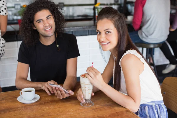 Paar met behulp van mobiele telefoon terwijl het hebben van dranken — Stockfoto