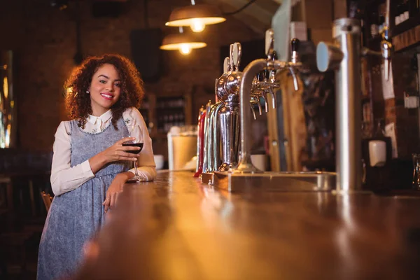 Young woman having wine at counter — Stock Photo, Image